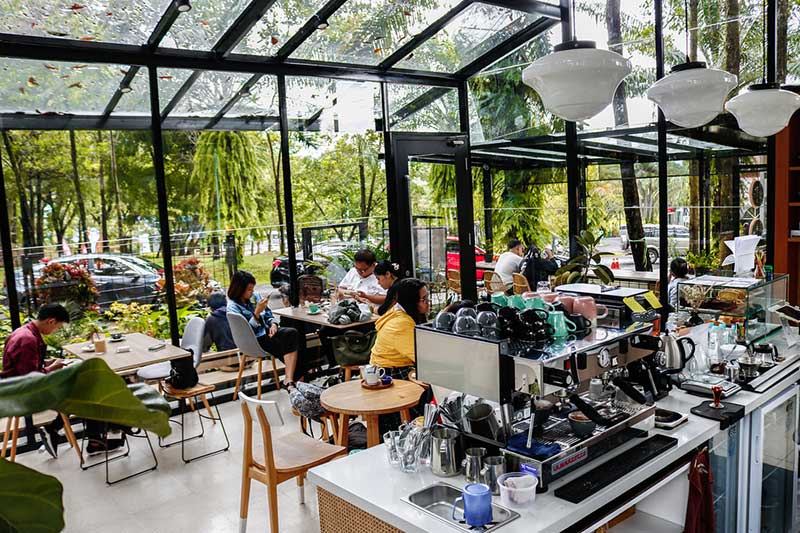 Popolo COffee dipenuhi pengunjung yang duduk di kursi kafe. Tampak espresso machine berwarna silver di cafe. Coffee shop Bogor.
